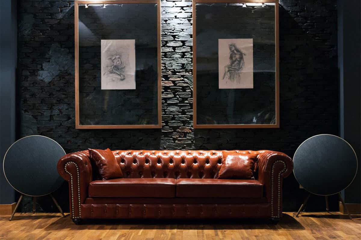Basement renovations with a nice couch and artwork against a stone wall.